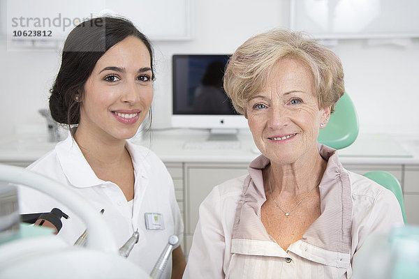 Zahnärztin und lächelnde Seniorin im Zahnarztstuhl