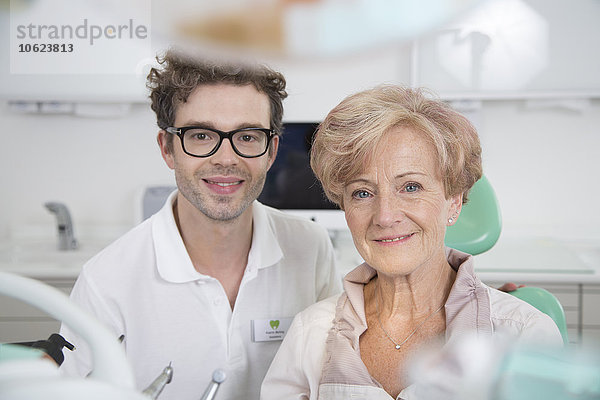 Zahnärztin und lächelnde Seniorin im Zahnarztstuhl