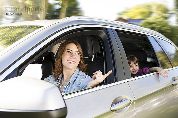 Frau fährt Auto mit Mädchen auf dem Rücksitz