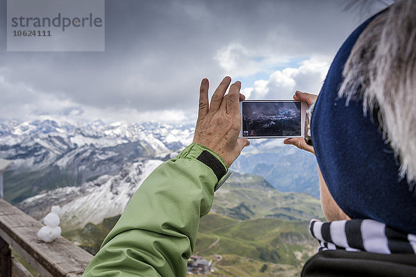 Deutschland  Bayern  Oberstdorf  Seniorin beim Handyfoto vom Gipfel des Nebelhorns