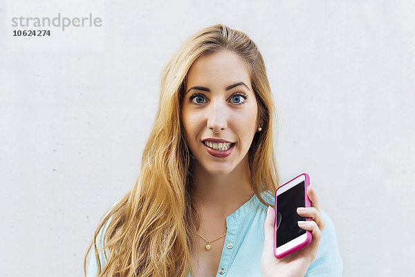 Portrait einer jungen blonden Frau mit Smartphone
