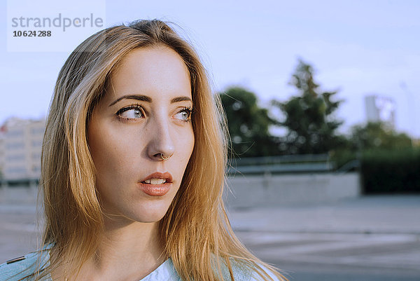 Portrait einer jungen blonden Frau mit Nasenpiercing