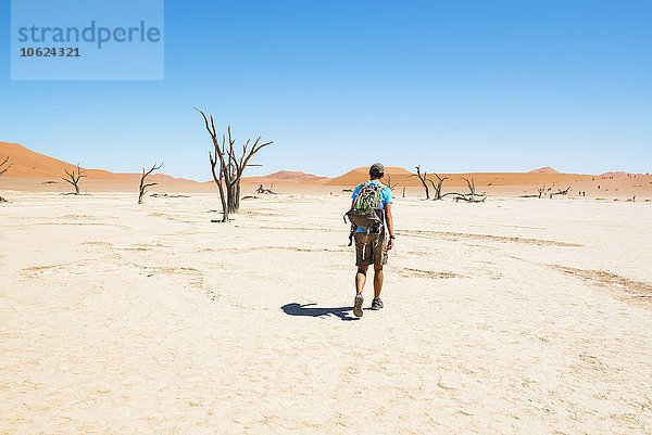 Namibia  Namib Wüste  Mann mit Rucksack wandert durch Deadvlei