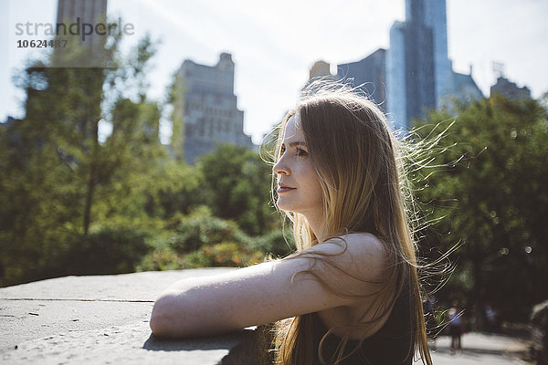 USA  New York City  junge Frau an die Wand gelehnt im Central Park