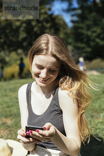 Junge Frau beim Telefonieren im Park