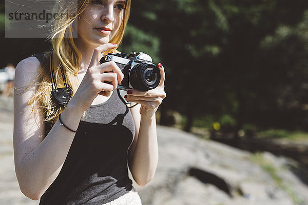 Junge Frau im Freien mit Kamera