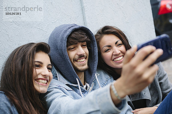Drei Freunde  die einen Selfie mit dem Handy nehmen.