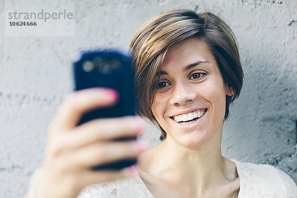 Lächelndes Teenagermädchen  das einen Selfie nimmt.