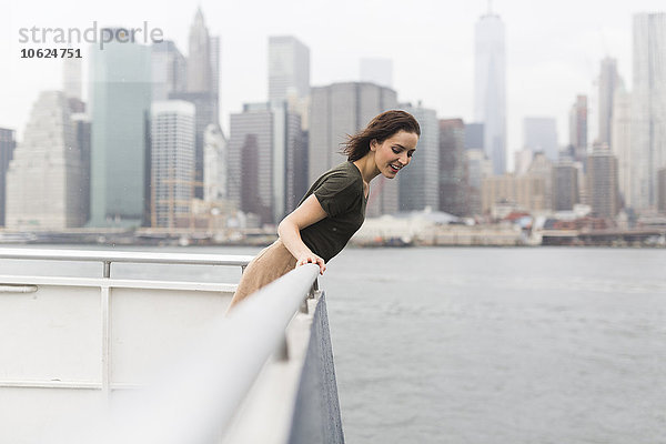 USA  New York City  junge Frau auf einem Ausflugsboot vor der Skyline stehend