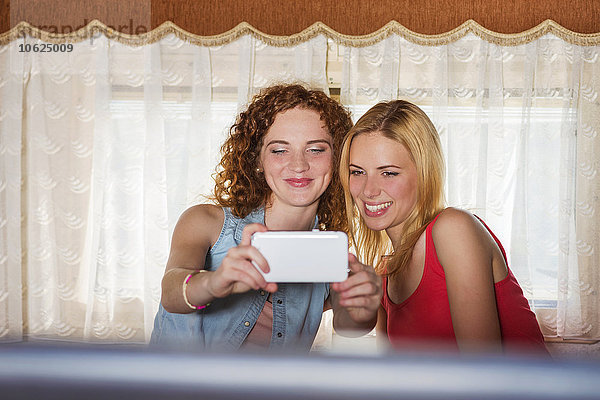 Zwei Freundinnen  die einen Selfie in einem Wohnwagen mitnehmen.
