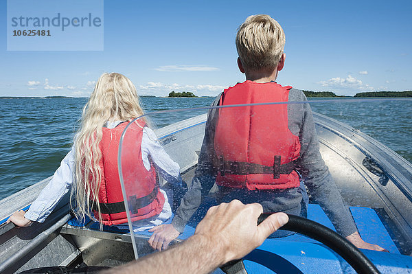 Finnland  Turku-Archipel  Houtskaer  Vater und seine beiden Kinder beim Motorbootfahren