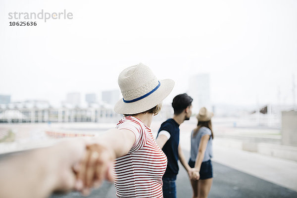 Spanien  Barcelona  vier Freunde  die Händchen halten