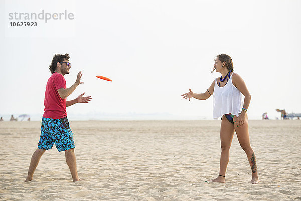 Spanien  Cadiz  El Puerto de Santa Maria  Paar beim Frisbee spielen am Strand