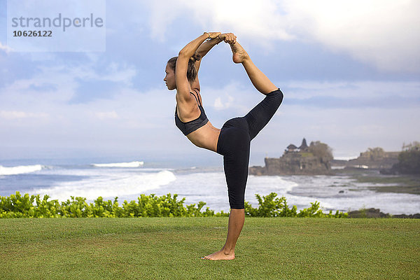 Indonesien  Bali  Tanah Lot  Yoga praktizierende Frau an der Küste