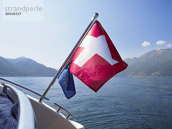 Schweiz  Tessin  Lago Maggiore  Schiff mit Schweizer und EU-Flagge auf dem See