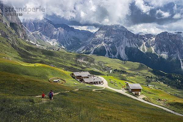Italien  Dolomiten  Odle-Gebirge  Wanderer auf dem Weg zu einem Chalet