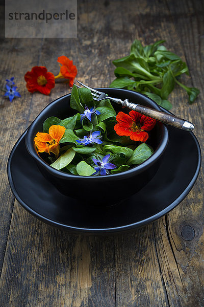 Schale mit Feldsalat mit Borretschblüten und indischer Kresse