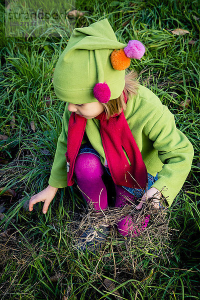 Kleines Mädchen spielt auf einer Wiese im Herbst