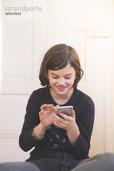 Porträt eines lächelnden Mädchens mit Smartphone