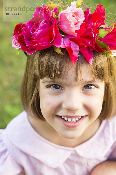 Porträt eines lächelnden kleinen Mädchens mit Blumen