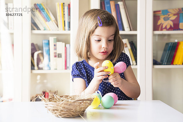 Kleines Mädchen spielt mit Ostereiern