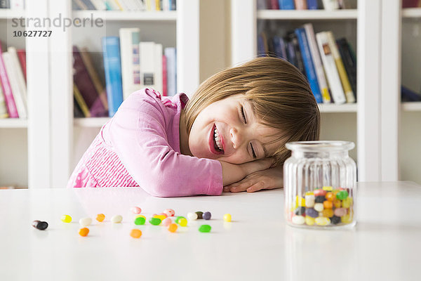 Porträt eines glücklichen kleinen Mädchens mit einem Glas Geleebohnen