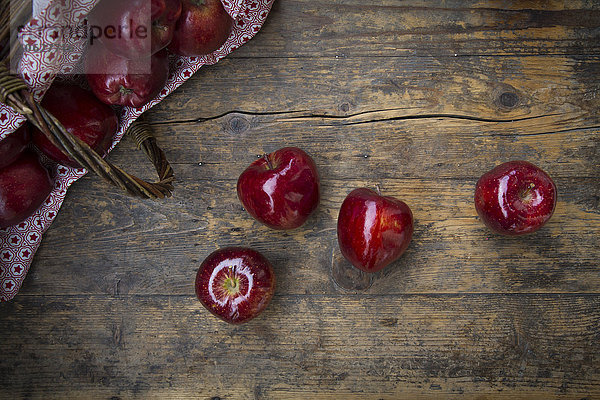 Vier rote Äpfel auf dunklem Holz