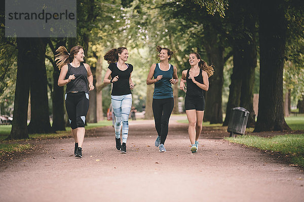 Vier Frauen joggen im Park