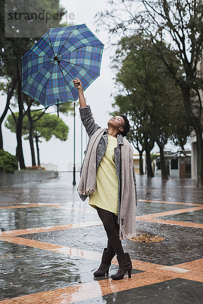 Italien  Grado  Frau mit Regenschirm an einem Regentag im Herbst