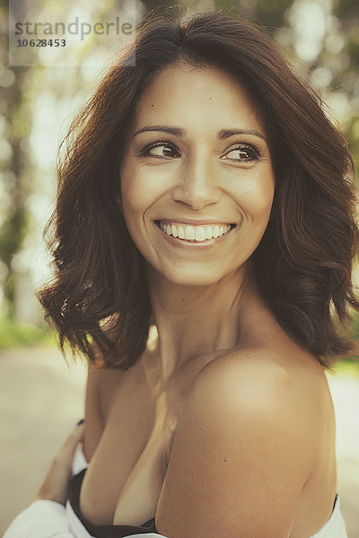 Porträt einer lächelnden Frau mit braunen Haaren