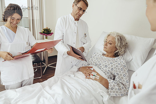 Seniorin im Krankenhaus mit Ärzten an ihrem Bett bei der Visite