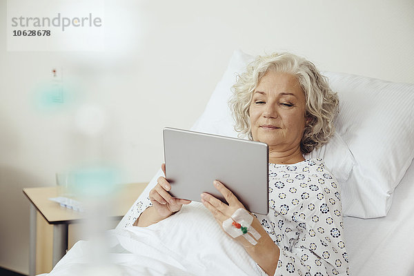 Seniorin im Krankenhaus mit digitalem Tablett