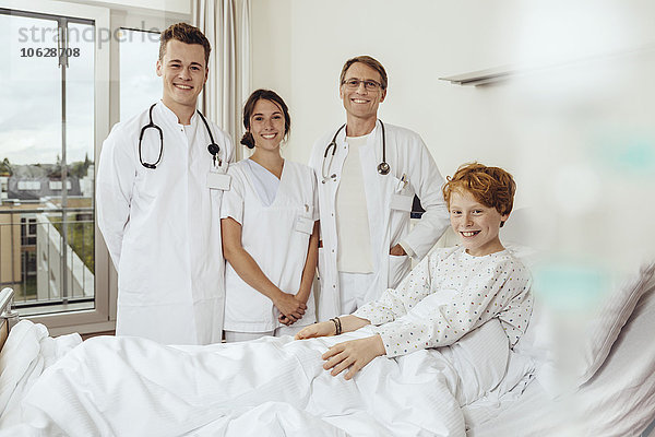 Ärzte im Krankenhaus stehen am Bett des kranken Jungen