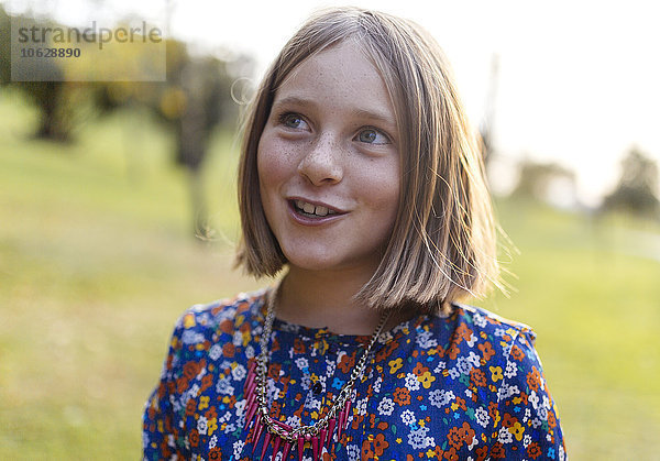 Porträt eines lächelnden blonden Mädchens mit Sommersprossen