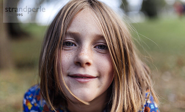 Porträt eines lächelnden Mädchens mit Sommersprossen