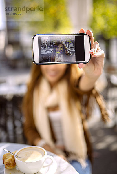 Spanien  Gijon  Junge Frau im Cafe  Selbstbedienung mit Smartphone  Nahaufnahme