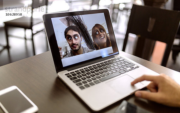 Lustige Fotografie des jungen Paares auf dem Display des Laptops