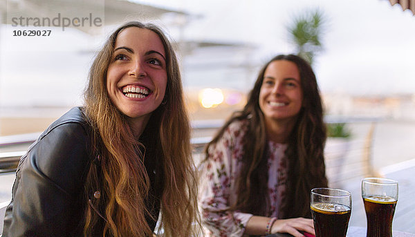 Porträt einer lächelnden Teenagerin und ihrer Freundin im Hintergrund