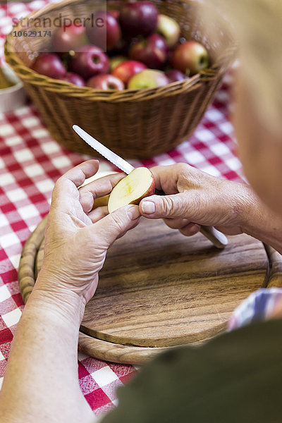 Seniorin beim Äpfelschneiden  Nahaufnahme