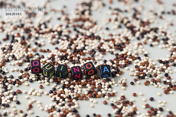 Verstreute Mischung aus Quinoa und Würfeln  die das Wort Quinoa bilden.