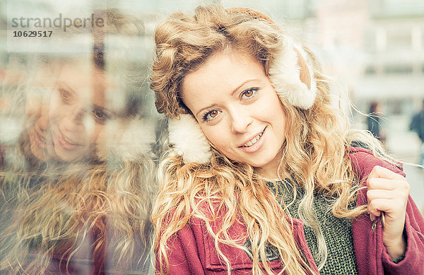 Porträt einer lächelnden blonden Frau mit Ohrenschützerin