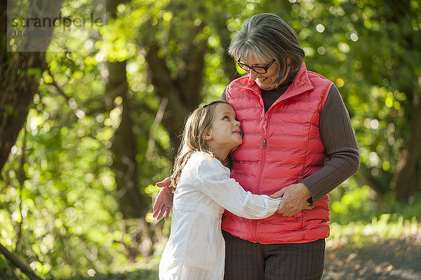 Kleines Mädchen umarmt Großmutter