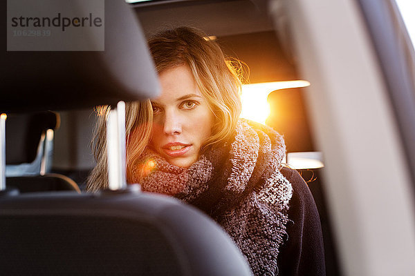 Porträt einer jungen Frau auf dem Rücksitz eines Autos