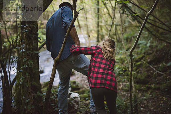 Vater und Tochter wandern durch den Wald