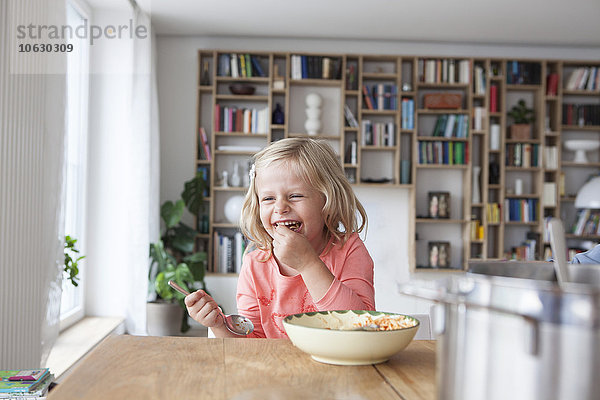 Porträt des lachenden kleinen Mädchens beim Spaghettiessen