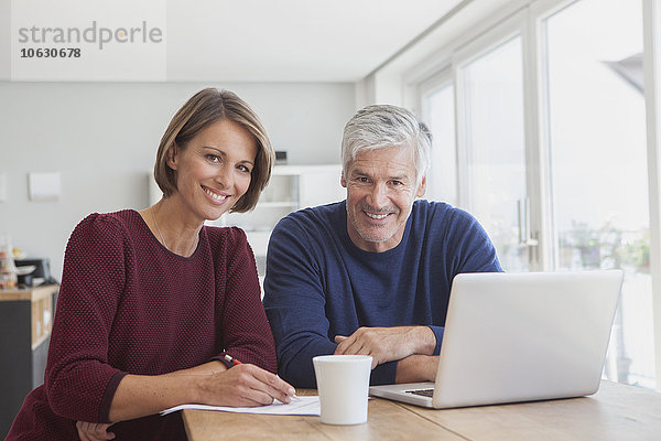 Porträt des lächelnden Paares mit Laptop zu Hause