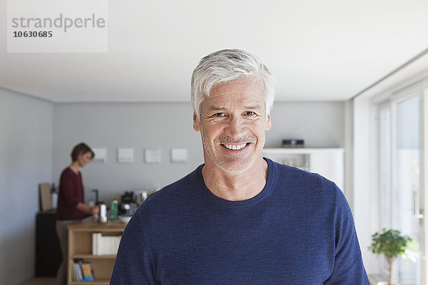 Porträt eines lächelnden Mannes mit grauen Haaren und Stoppeln zu Hause
