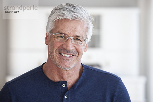 Porträt eines lächelnden reifen Mannes mit Stoppelbrille