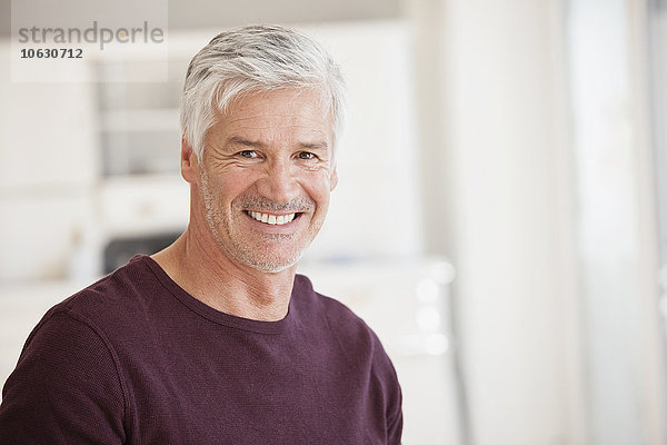 Porträt eines lächelnden reifen Mannes mit grauen Haaren und Stoppeln