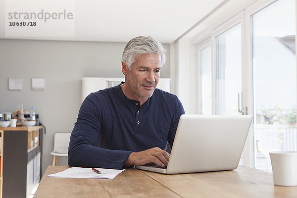 Porträt eines reifen Mannes mit Laptop zu Hause